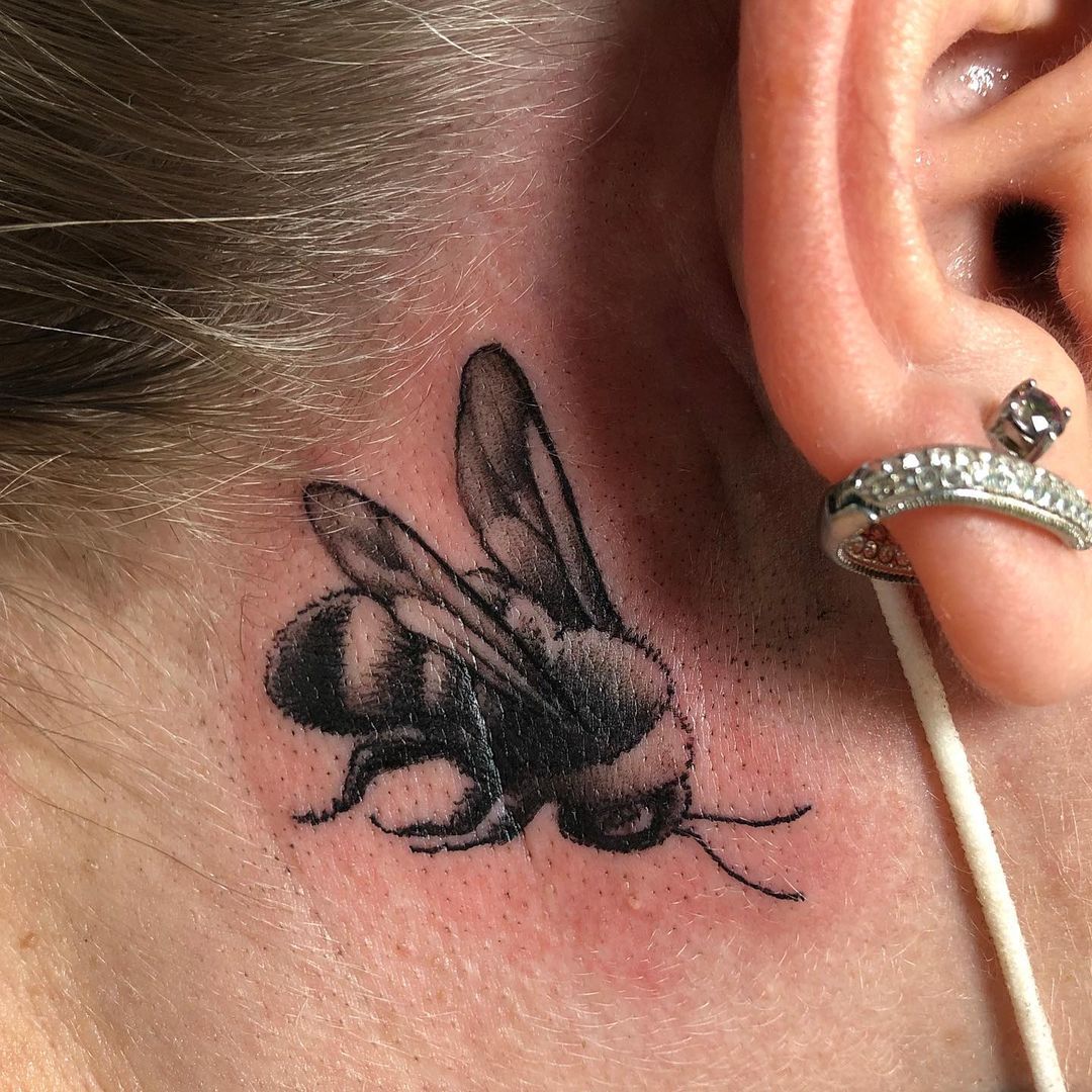 Tatuaje de abeja detrás de la oreja