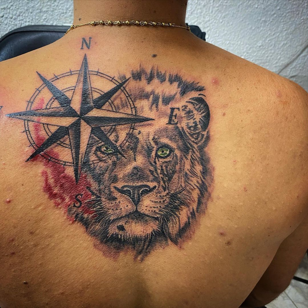 Tatuaje de brújula y león en la espalda