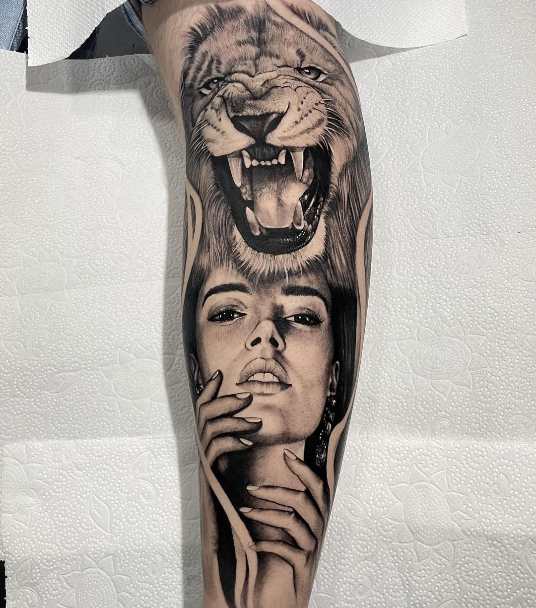 Tatuaje de mujer y león en el brazo