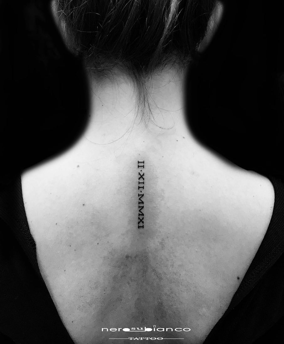 Tatuaje de fecha en la espalda superior