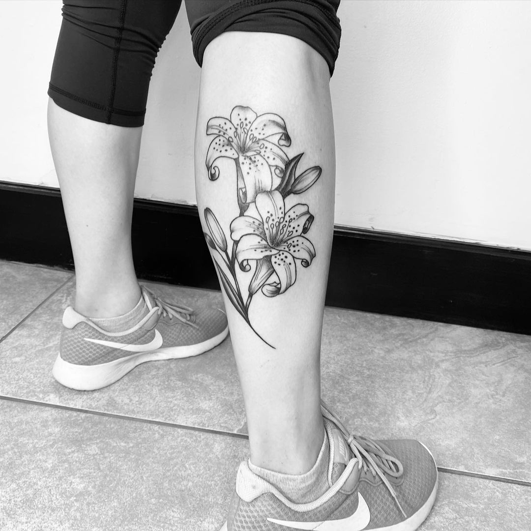 Tatuaje de lirio de tinta negra con diseño de pierna