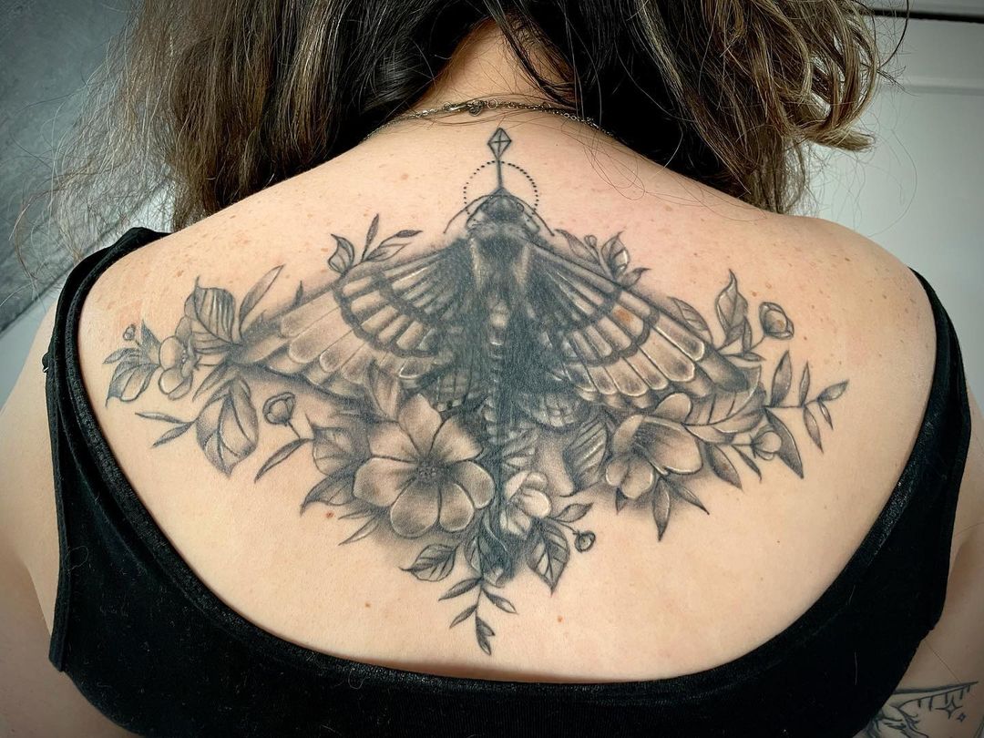 Tatuaje de una flor en la parte superior de la espalda