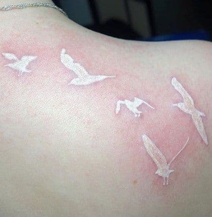 Weiße Tinte Tattoos auf dunkler Haut Hero tattoo Birds 1