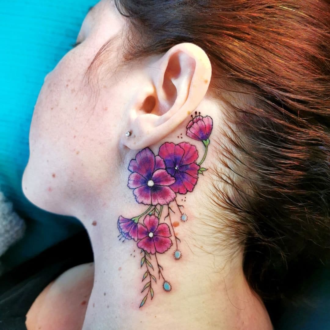Colorful flower behind the tattoo hero tattoo