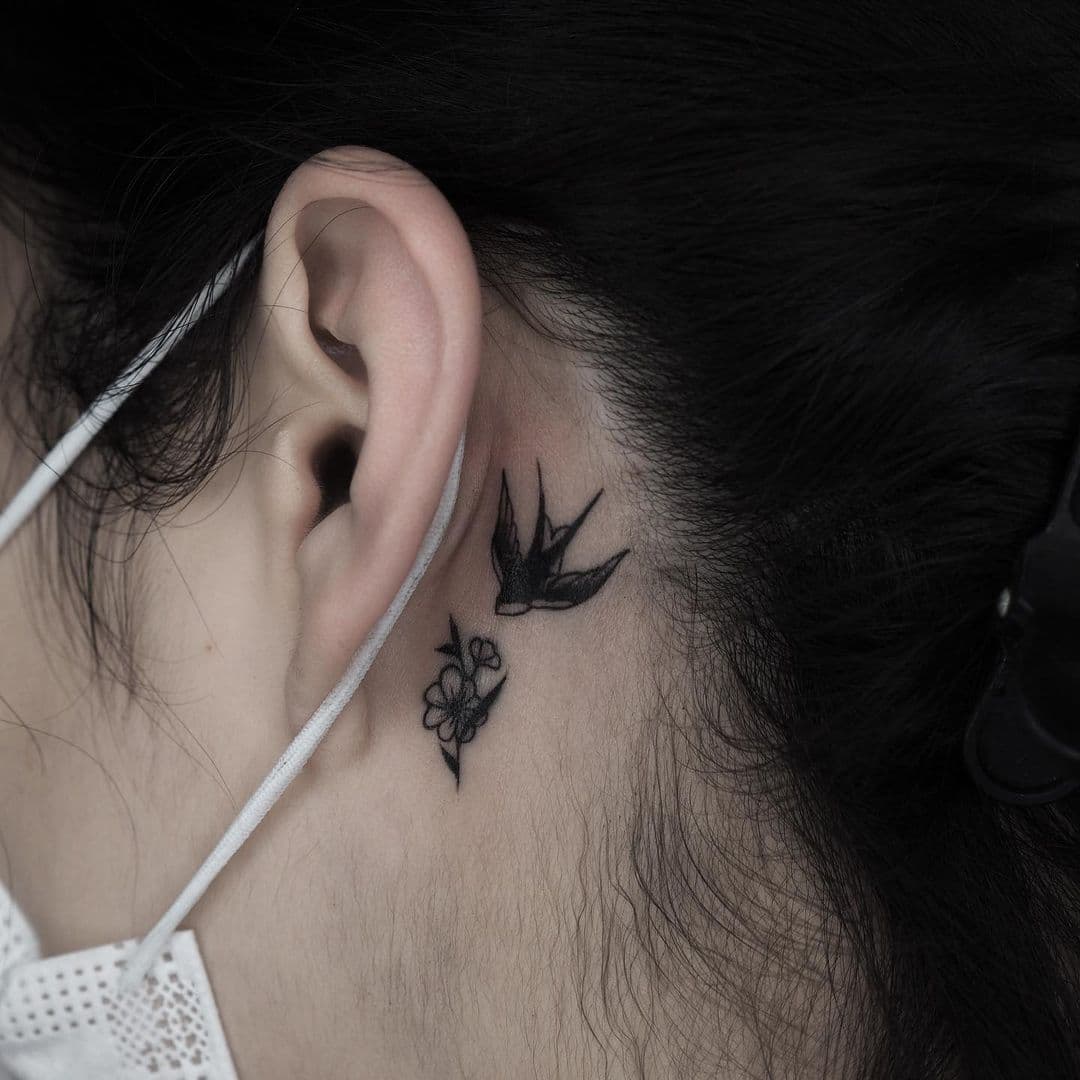Schwalbe Tattoo hinter dem Ohr