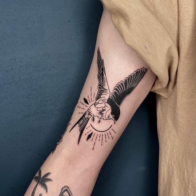 Tatuaje de golondrina en el brazo