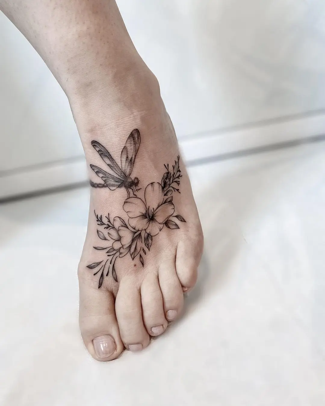 tatuaje de flor en el pie