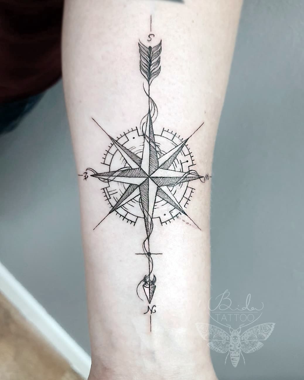 Pfeil-Tattoo auf der Hand mit Kompass