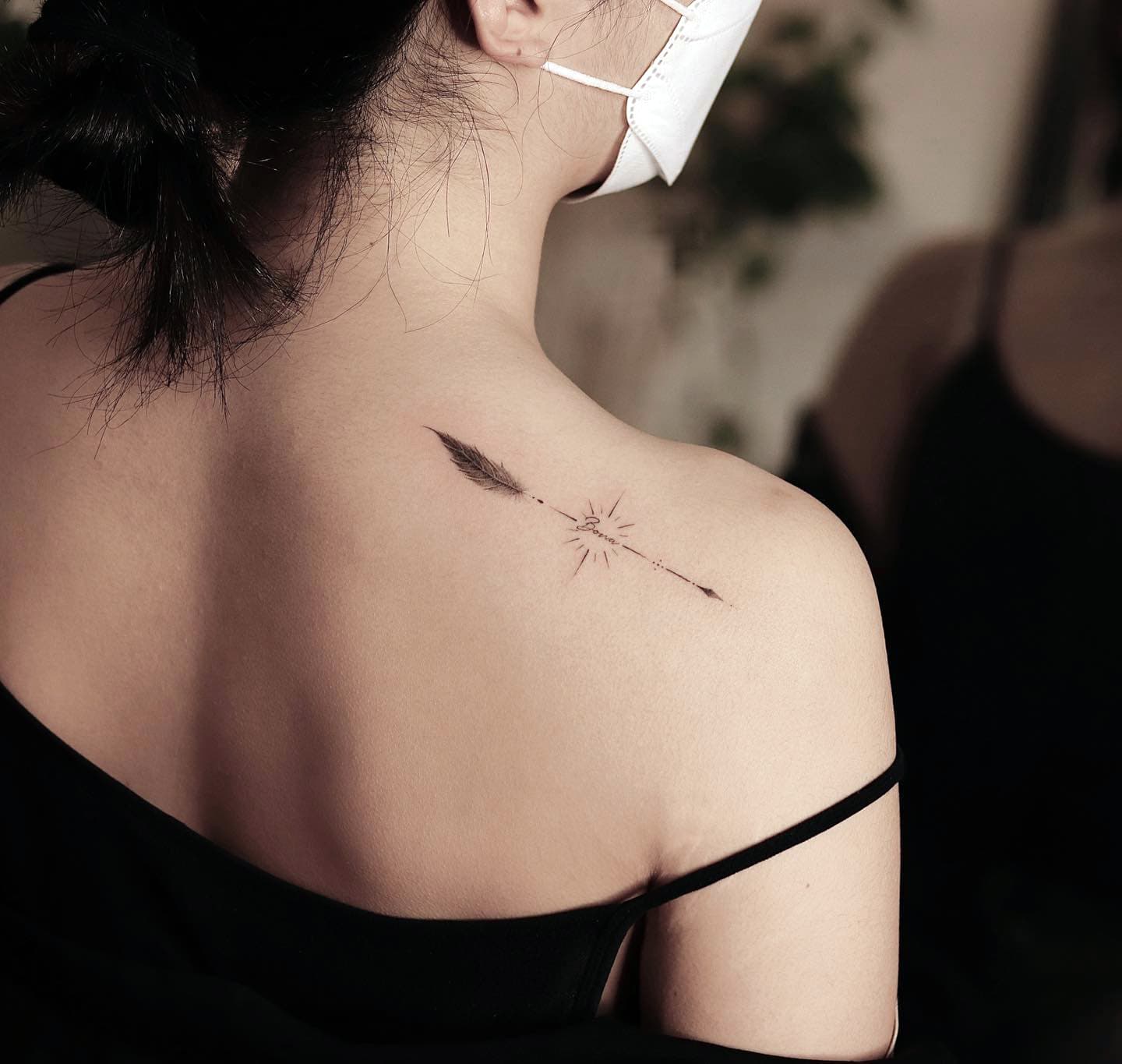 Tatuaje de flecha con pluma sobre el pecho
