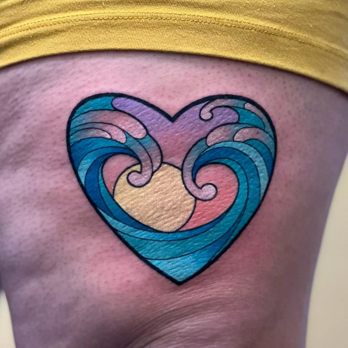 Dramatisches und farbenfrohes Herz-Tattoo mit Farbspritzern