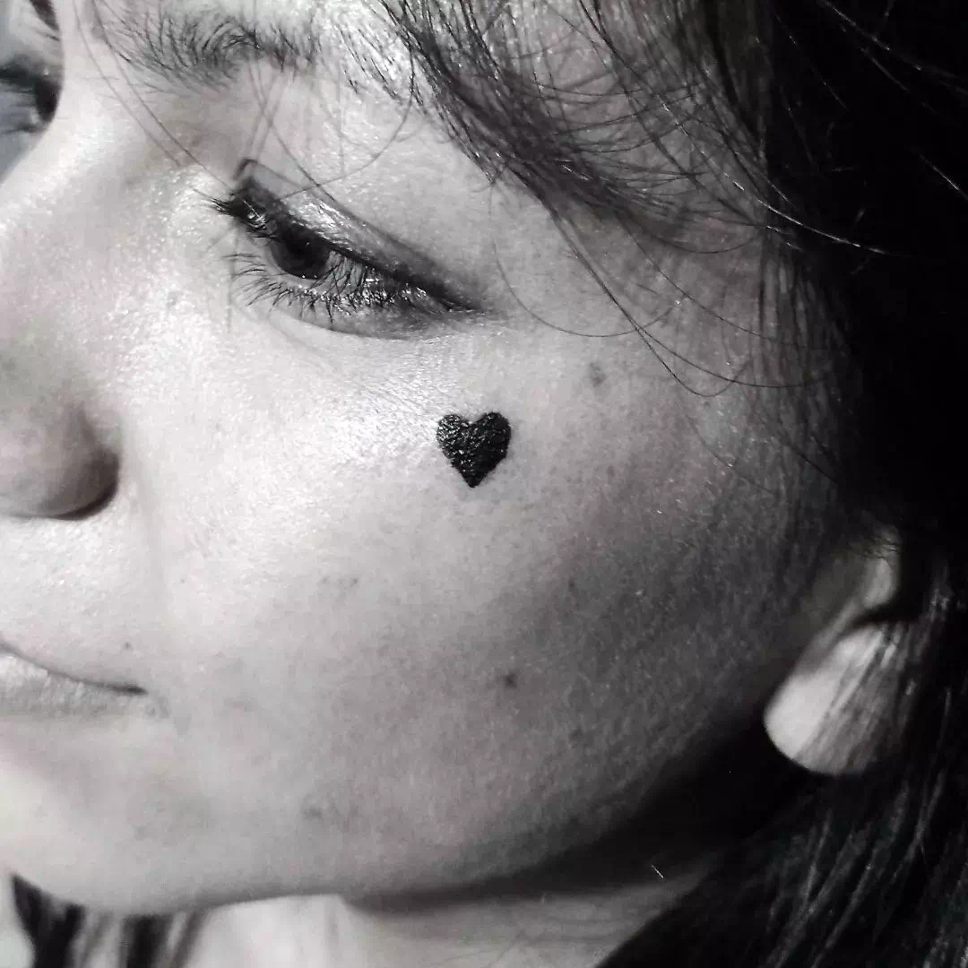 kleines Herz Tattoo im Gesicht