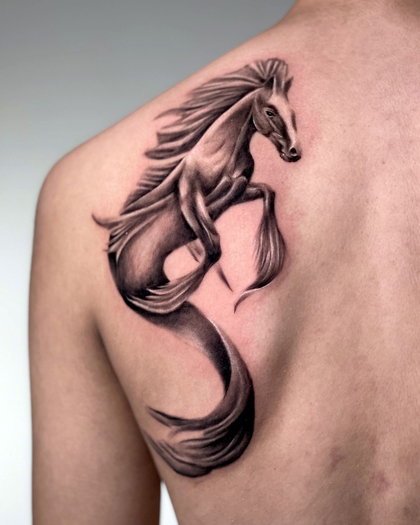Tatuaje de un caballito de mar en el hombro