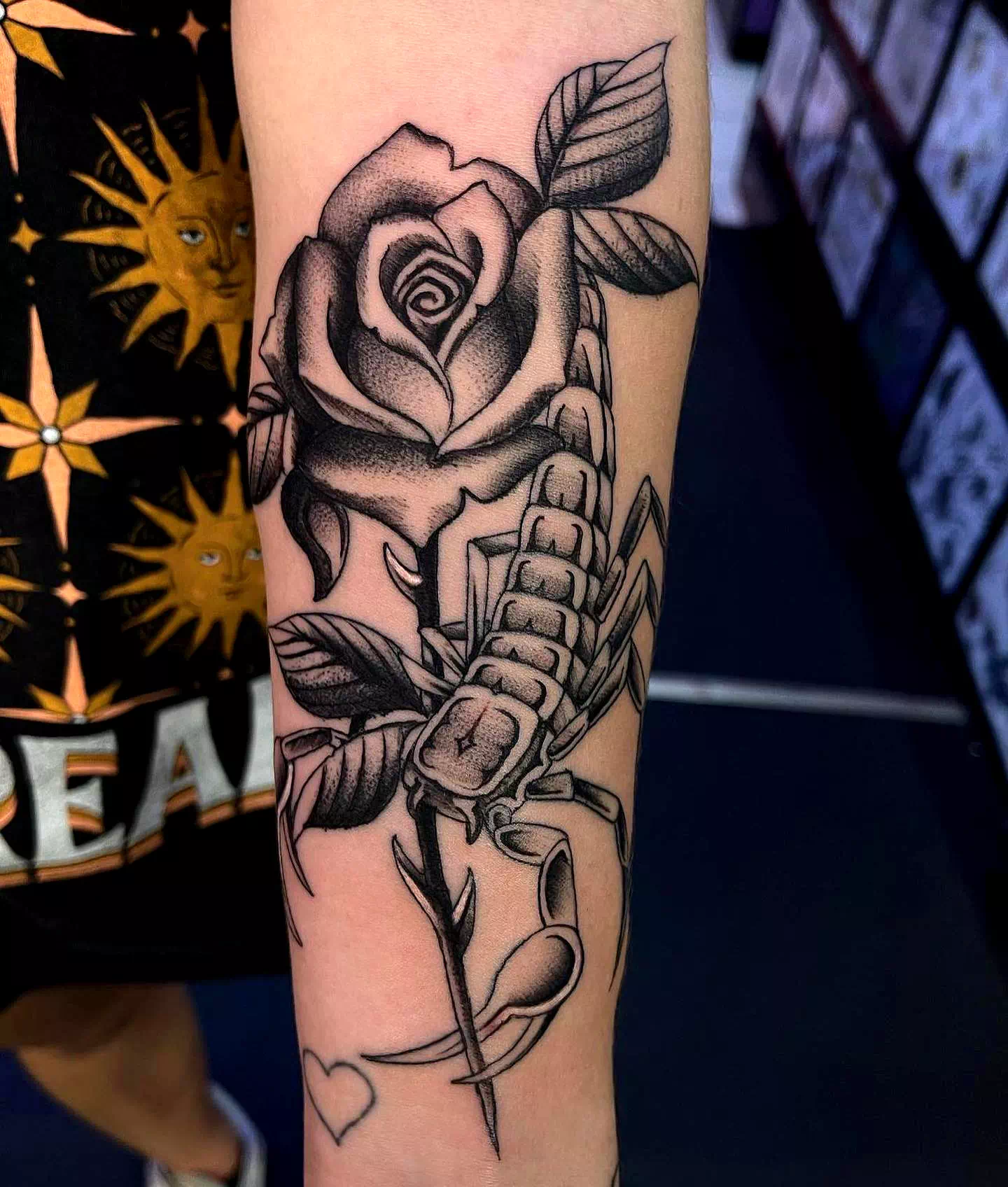 Tatuaje de Escorpio negro con detalle de rosa