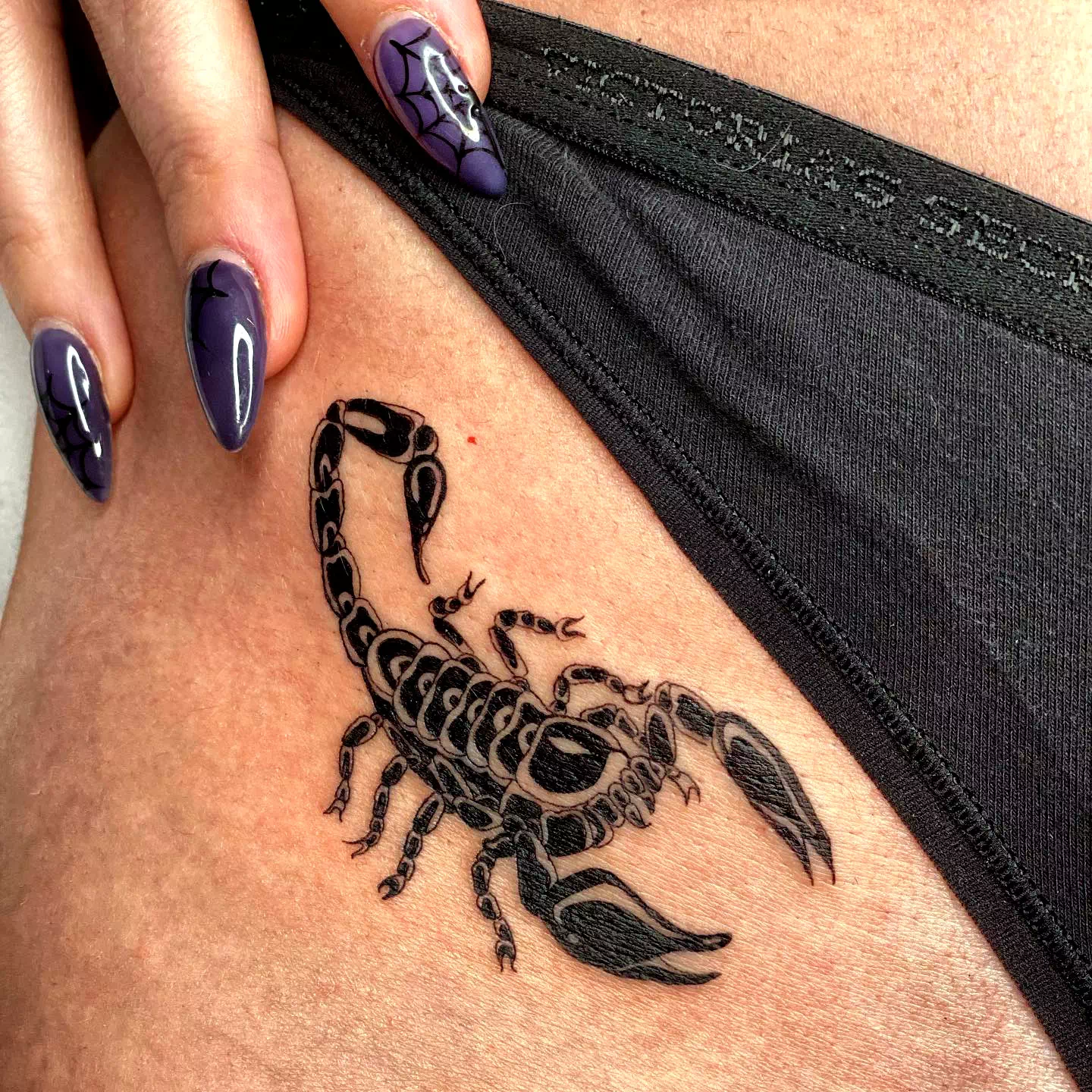 Schwarzer Skorpion Tattoo auf Oberschenkel 2