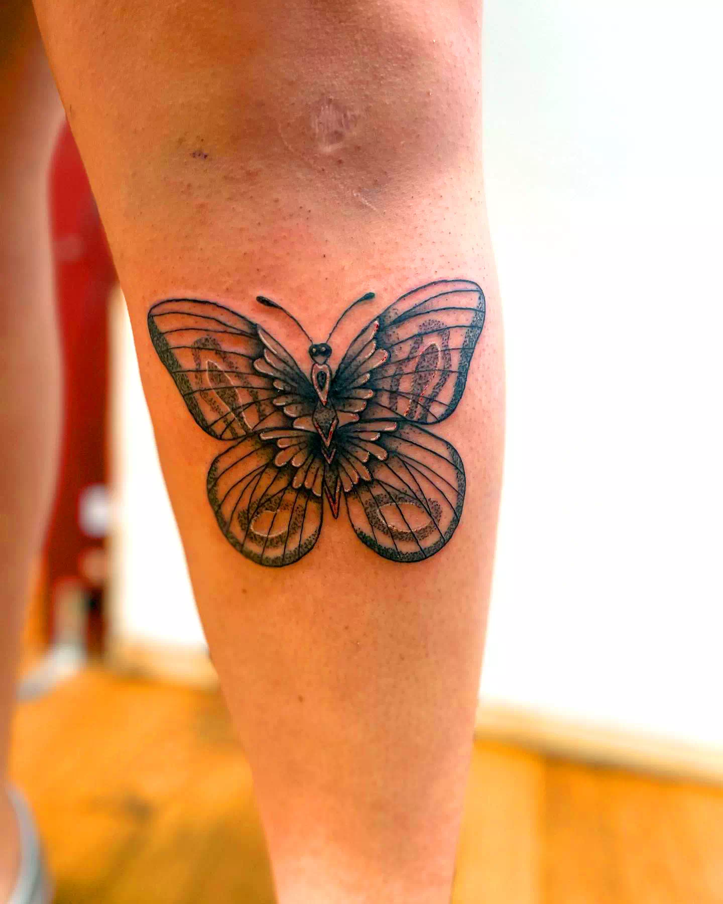 Tatuaje único de mariposa negra en la pantorrilla