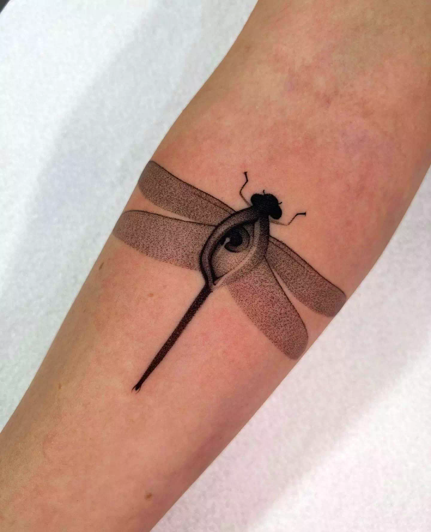 Tatuaje de libélula en el brazo