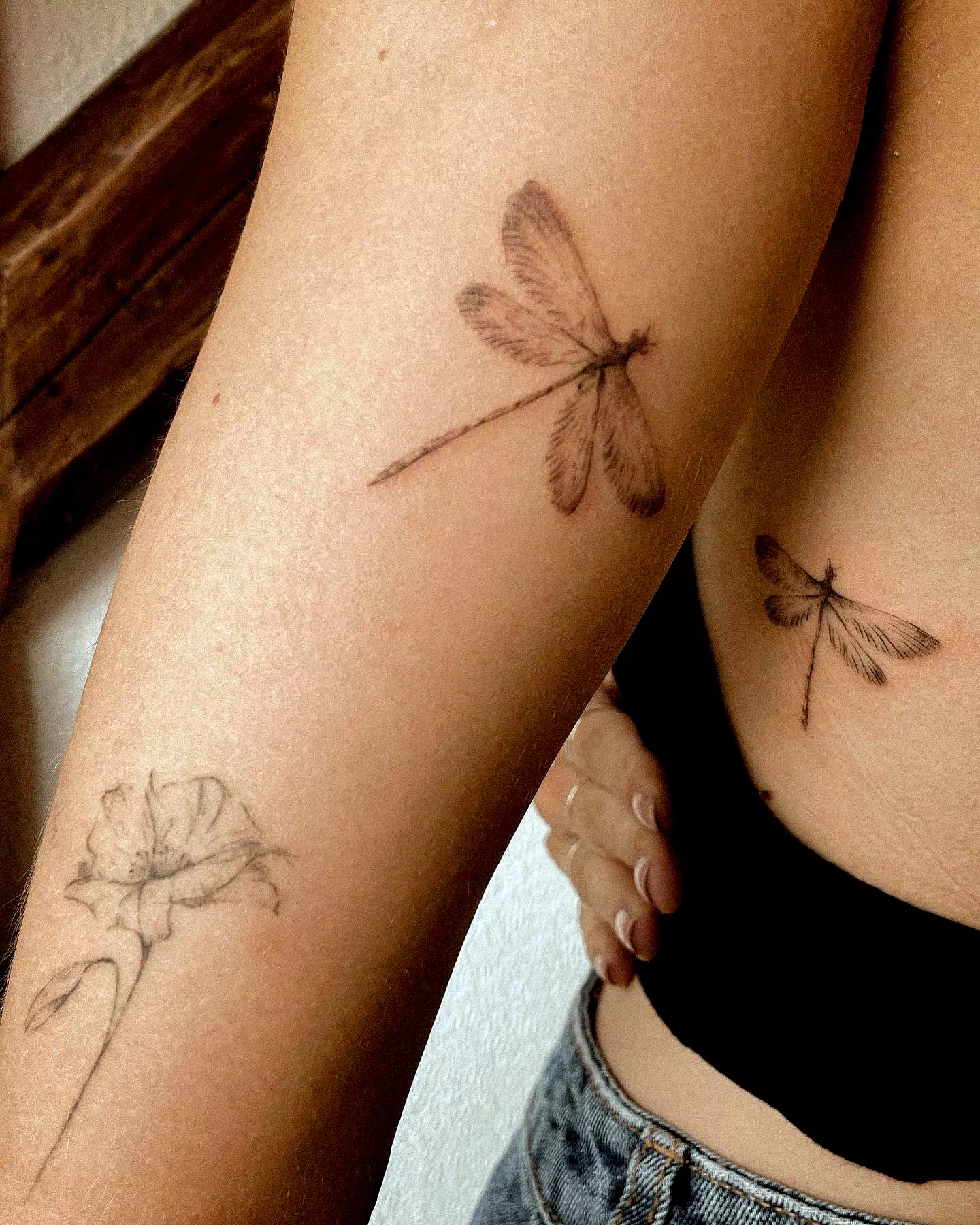 Tatuaje de una pequeña libélula con tinta negra