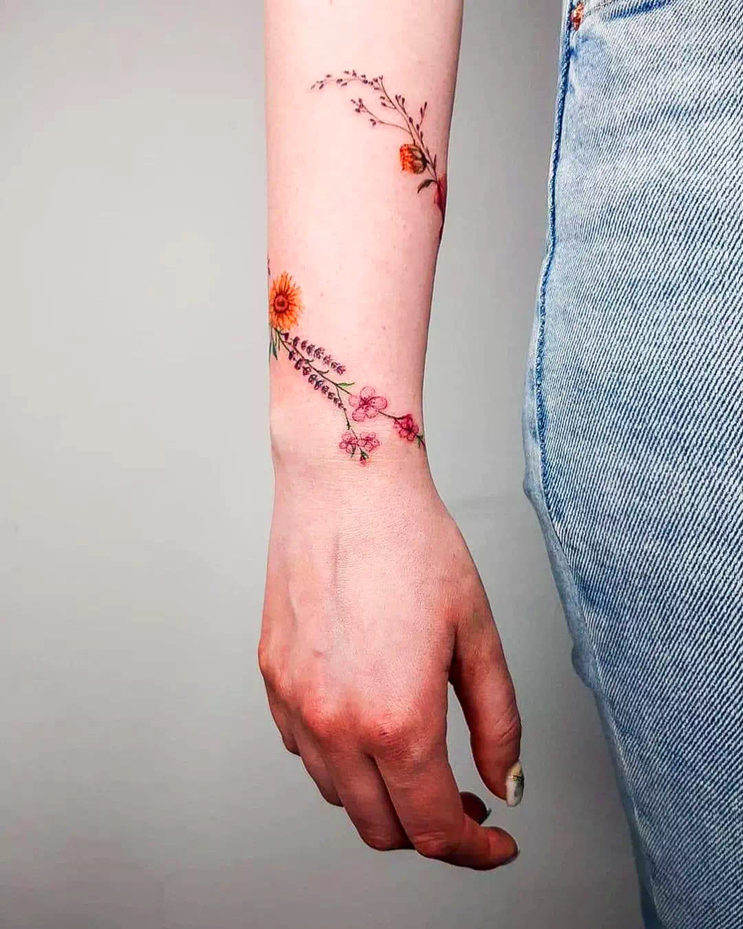 Tatuaje de una flor en una pulsera pequeña de color púrpura