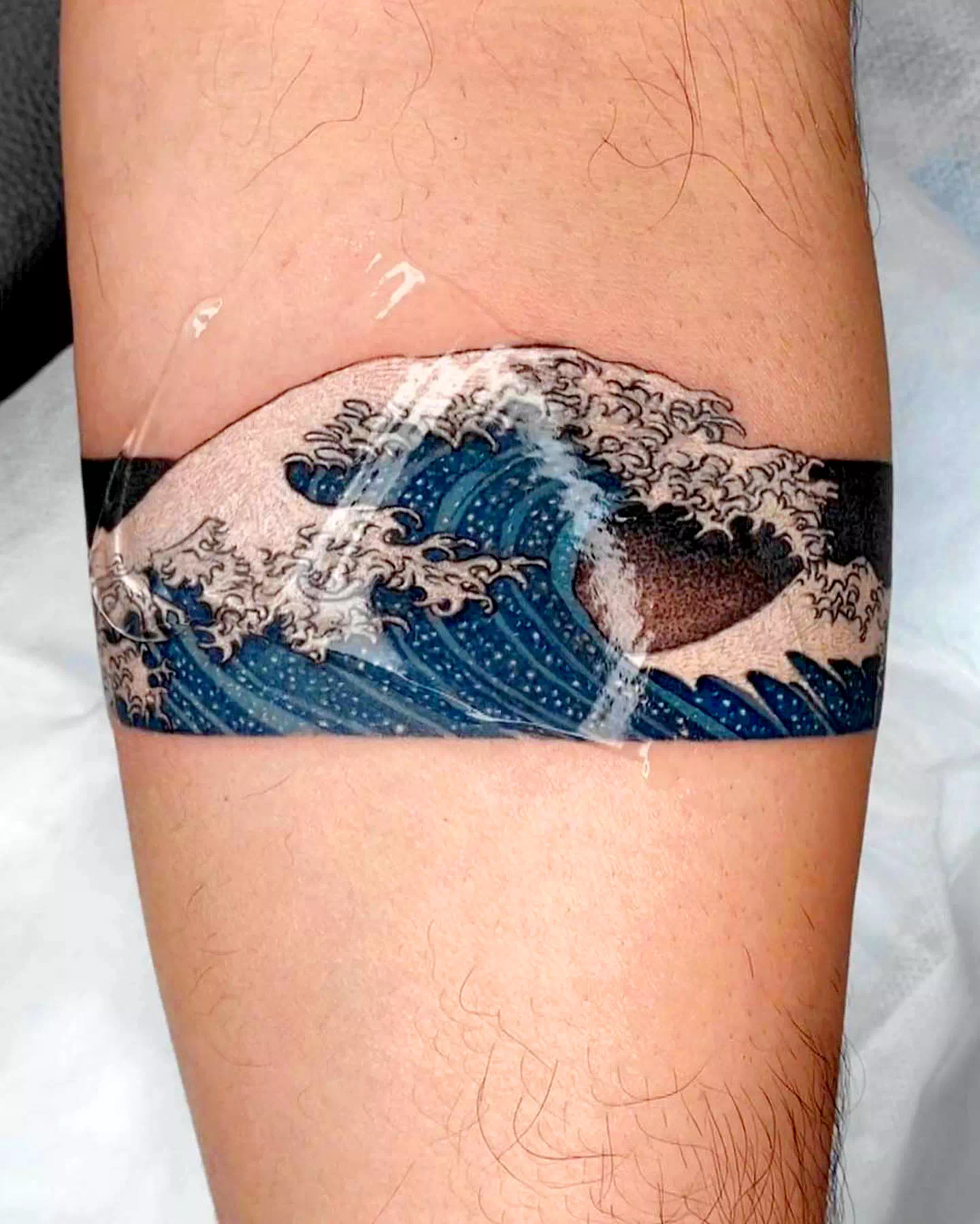 Tatuaje de brazalete inspirado en las olas
