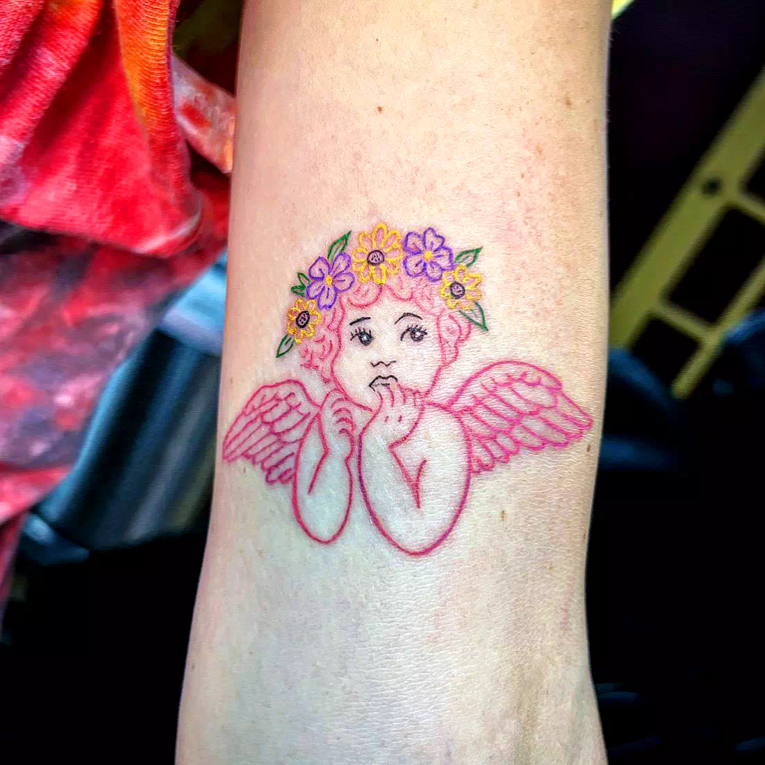 Cherub Tattoo mit einem Blumenstrauß