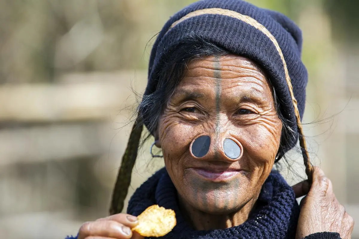 tribe man wearing a traditional headdress and body tattoo