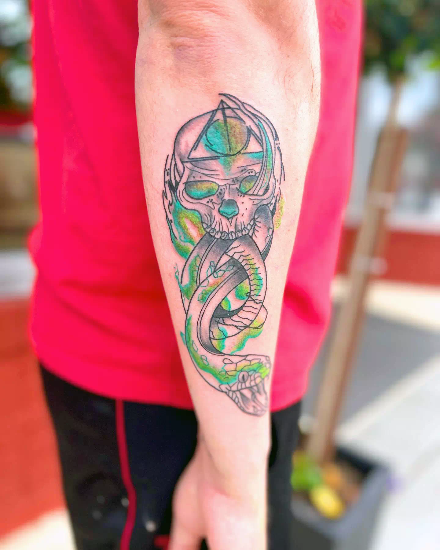 Tatuaje de un mortífago en el brazo verde
