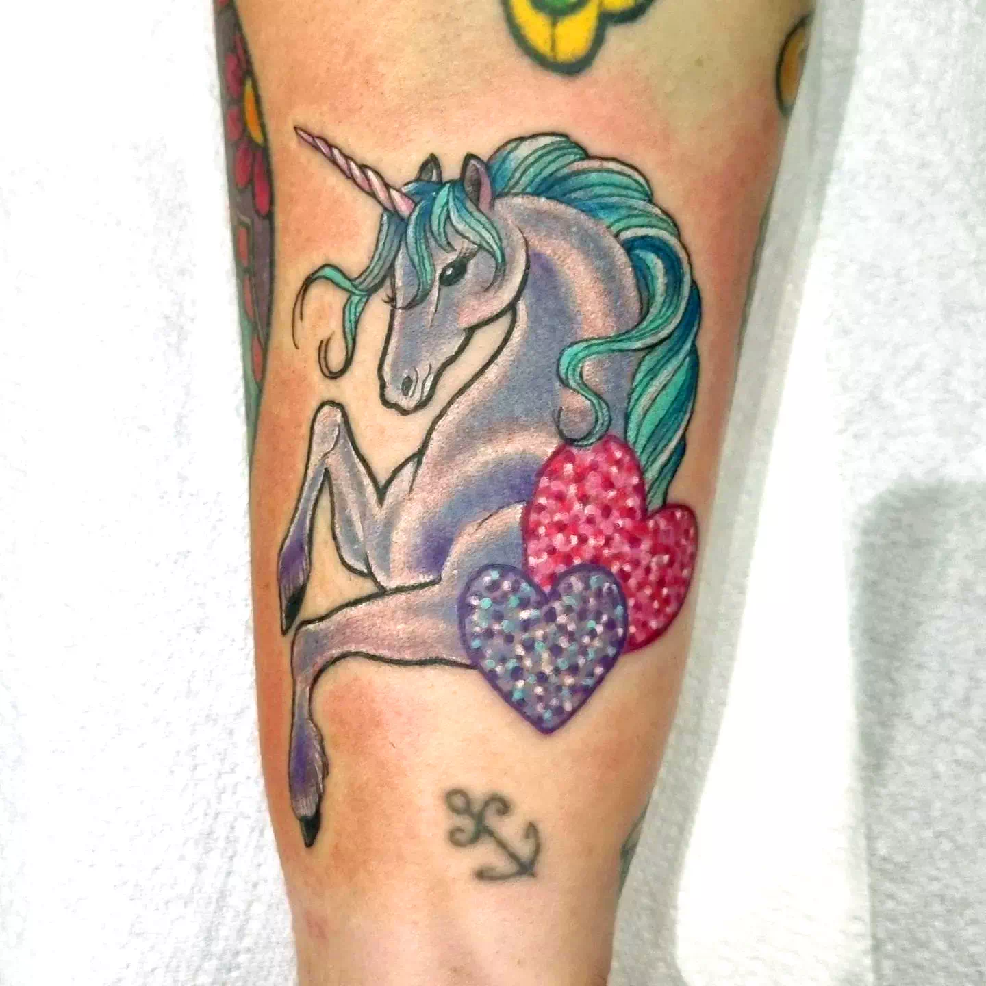 Diseño de tatuaje de unicornio con estampado de corazones
