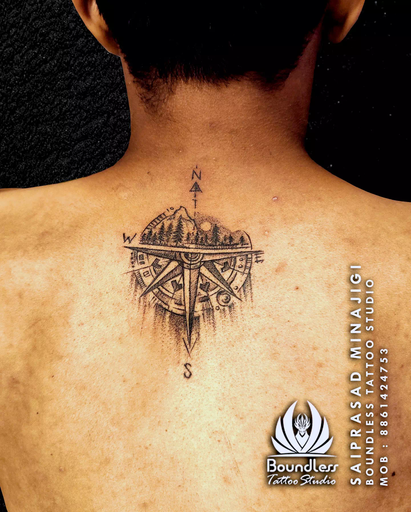 Pequeño y delicado tatuaje de brújula en la espalda