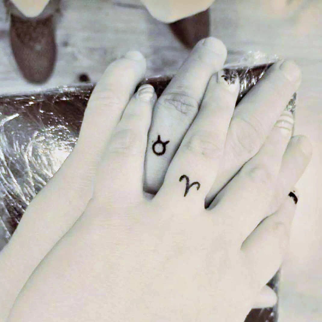 Tatuaje de anillo de boda con símbolos del zodiaco